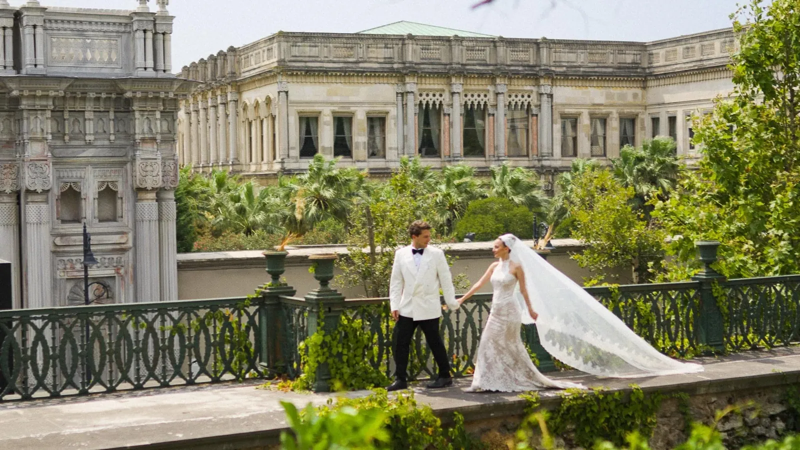 Bride and groom walking hand in hand at a palace in Istanbul