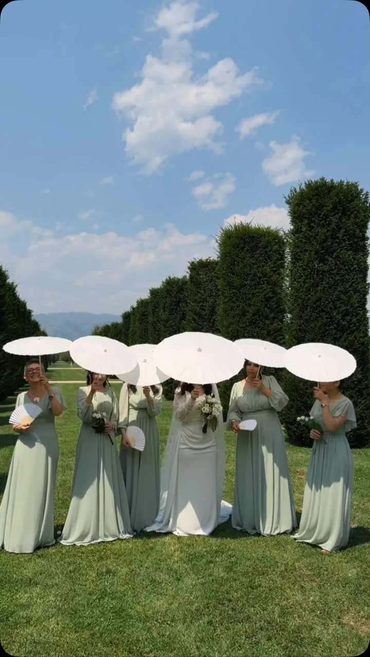 Bridesmaids with white parasols in the gardens of the Reggia di Venaria